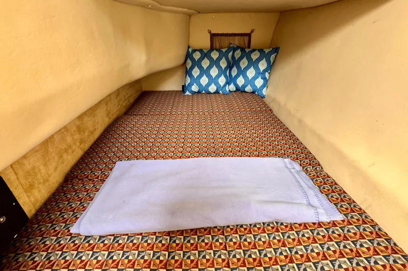 Slide: The Image of Cozy cabin interior of 2005 Monterey 298SS Super Sport with patterned bedding and blue pillows. - 13