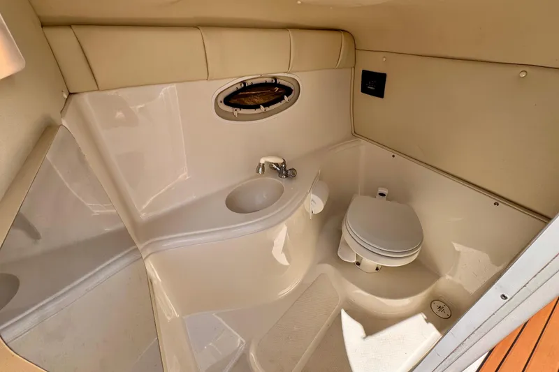 Slide: The Image of 2005 Monterey 298SS Super Sport boat bathroom with sink, toilet, and porthole window. - 14