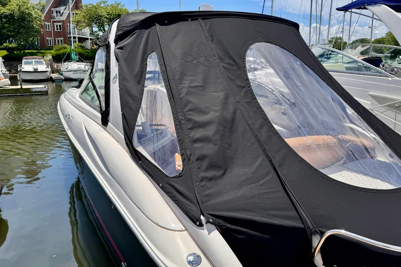 Slide: The Image of 2005 Monterey 298SS Super Sport boat with black canopy docked at marina. - 3
