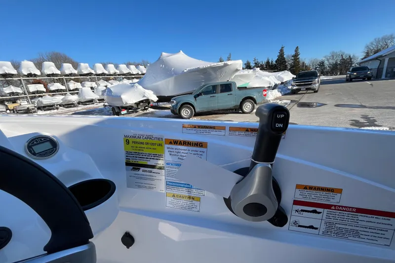 Slide: The Image of Interior view of 2026 Hurricane SunDeck Sport 185 OB boat with control lever and warning labels. - 16