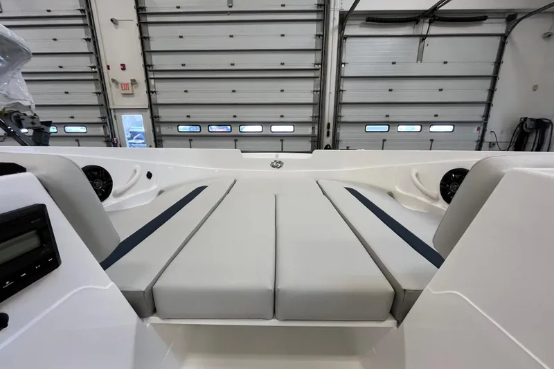 Slide: The Image of 2026 Hurricane SunDeck Sport 185 OB interior with cushioned seating in a garage setting. - 18