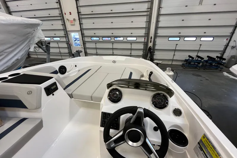 Slide: The Image of 2026 Hurricane SunDeck Sport 185 OB boat interior with steering wheel and dashboard in a garage. - 31