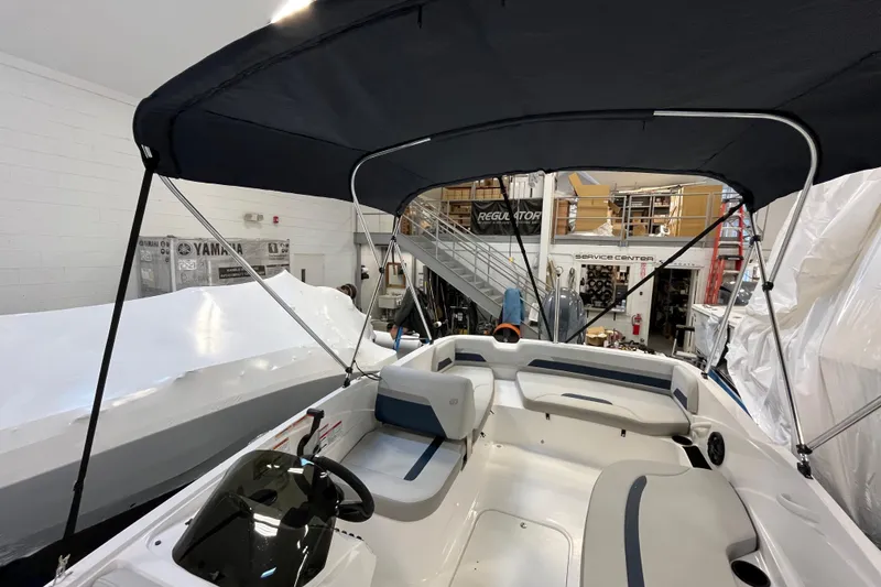 Slide: The Image of 2026 Hurricane SunDeck Sport 185 OB boat interior with canopy in a service center. - 36
