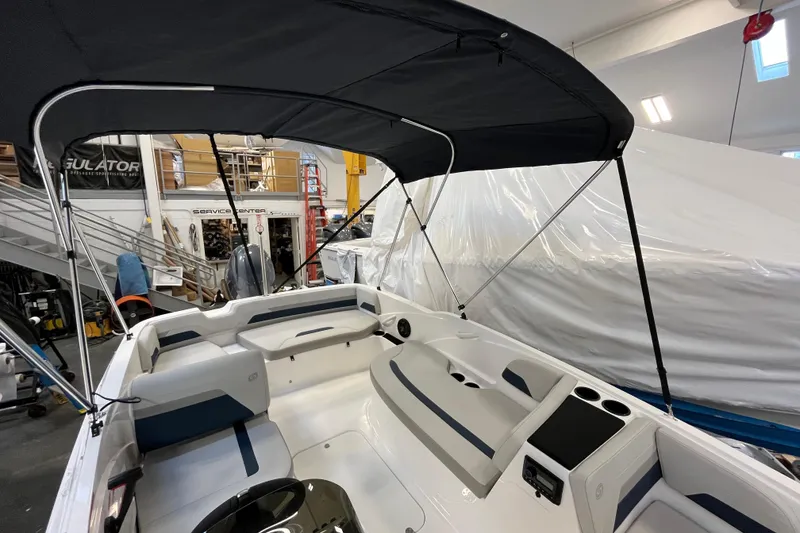 Slide: The Image of 2026 Hurricane SunDeck Sport 185 OB boat interior with canopy in a service center. - 37