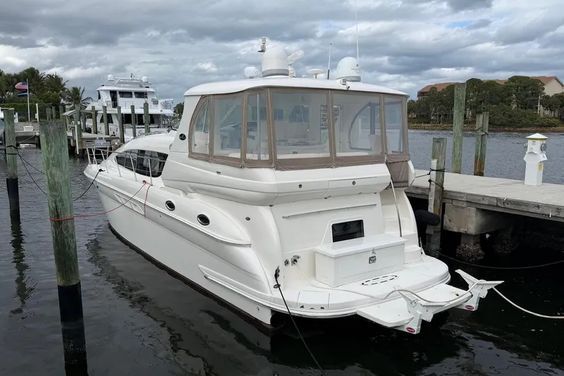 The Image of 2004 Sea Ray 480 Sedan Bridge yacht docked at marina under cloudy sky. - 0