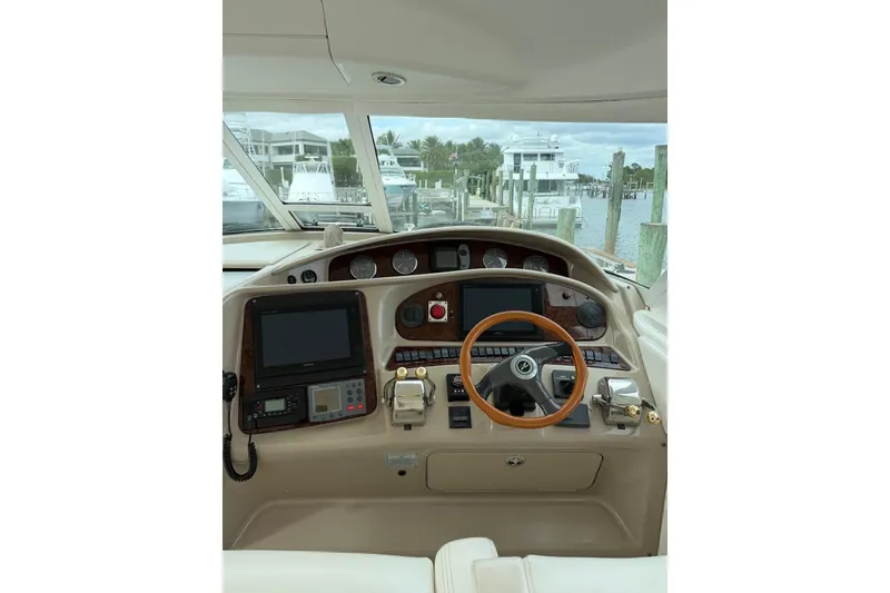 Slide: The Image of 2004 Sea Ray 480 Sedan Bridge helm with navigation equipment and wooden steering wheel. - 10
