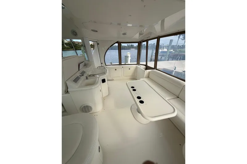 Slide: The Image of Interior of 2004 Sea Ray 480 Sedan Bridge yacht with white seating and table. - 12