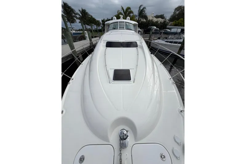 Slide: The Image of 2004 Sea Ray 480 Sedan Bridge yacht docked, showcasing sleek white deck design. - 2
