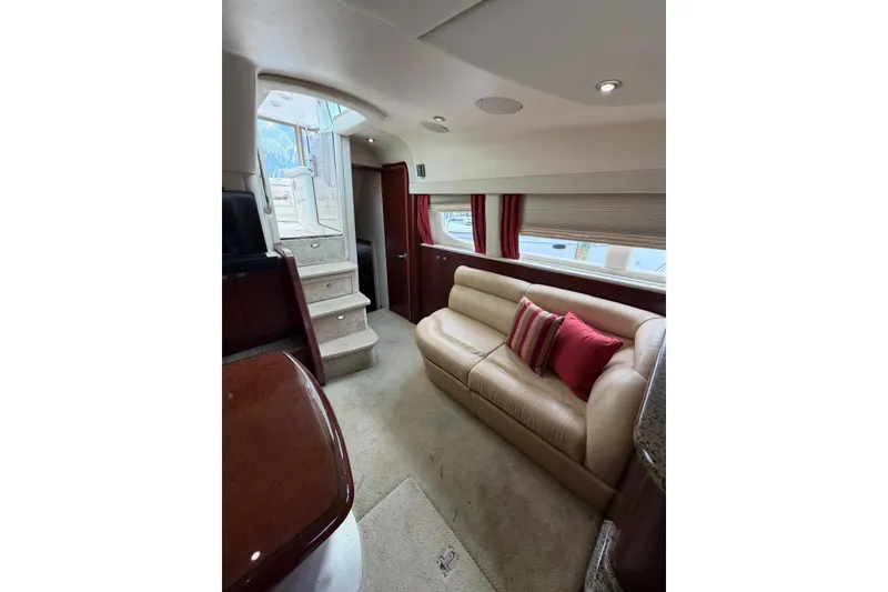 Slide: The Image of Luxurious interior of 2004 Sea Ray 480 Sedan Bridge with beige leather sofa and red accents. - 20