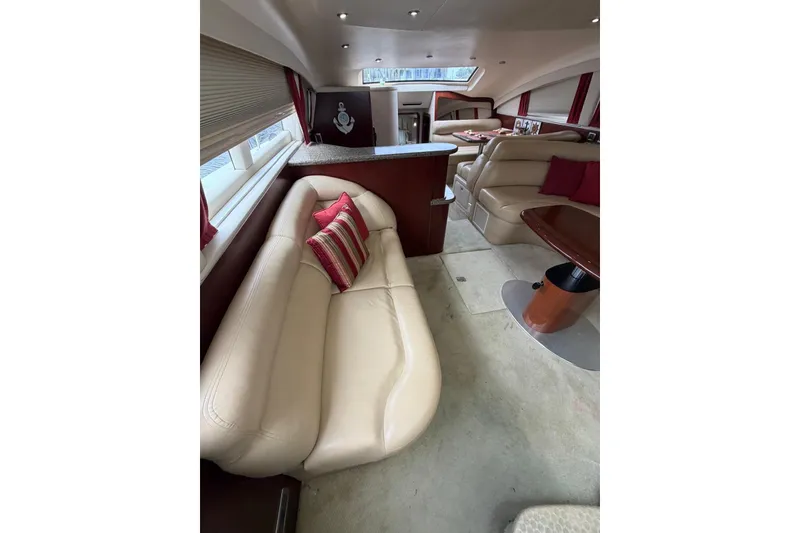 Slide: The Image of Luxurious interior of 2004 Sea Ray 480 Sedan Bridge with beige leather seating and red accents. - 29