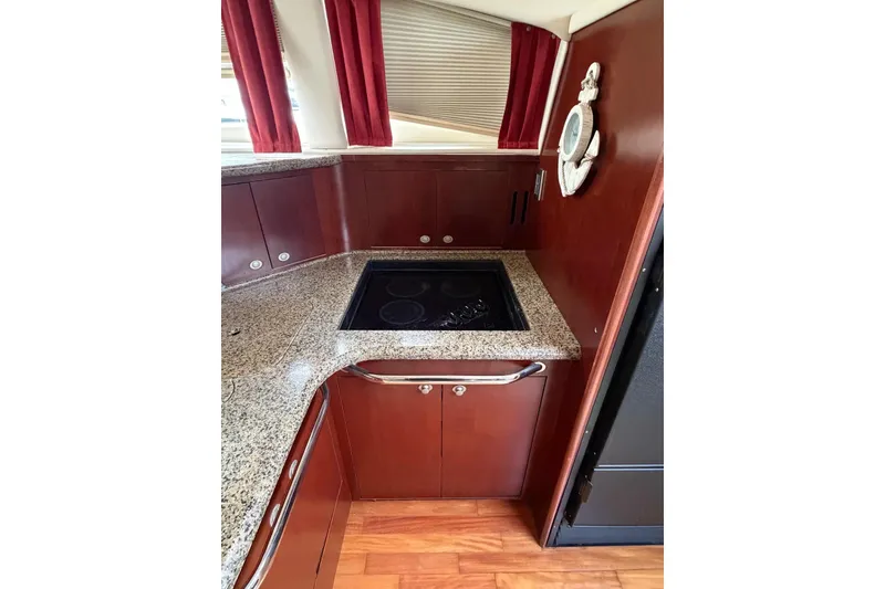 Slide: The Image of 2004 Sea Ray 480 Sedan Bridge kitchen with granite countertops and electric stove. - 35