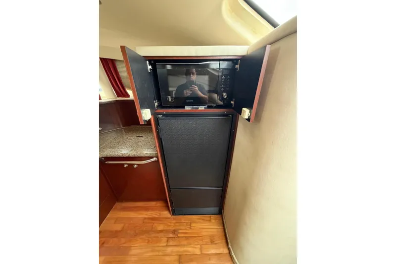 Slide: The Image of 2004 Sea Ray 480 Sedan Bridge interior with microwave and cabinetry. - 36