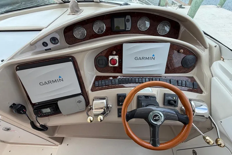 Slide: The Image of 2004 Sea Ray 480 Sedan Bridge helm with Garmin navigation and wooden steering wheel. - 4