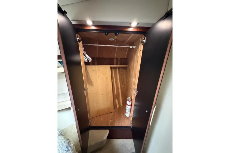 Slide: The Image of Open wooden closet with hangers and fire extinguisher on Sea Ray 480 Sedan Bridge, 2004. - 51