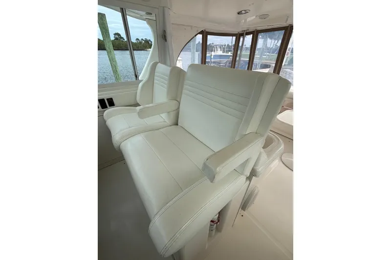 Slide: The Image of Luxurious white seating on 2004 Sea Ray 480 Sedan Bridge yacht, featuring panoramic windows. - 9