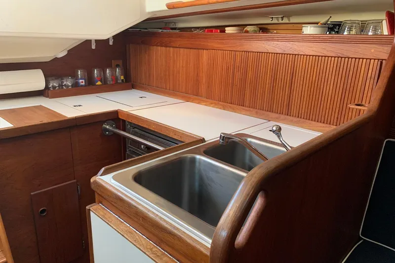 Slide: The Image of 1986 Sabre 34 MK II yacht kitchen with wooden cabinetry and stainless steel sink. - 26