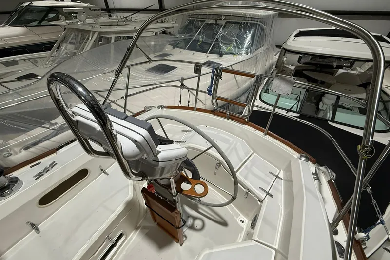 Slide: The Image of 1986 Sabre 34 MK II sailboat cockpit with steering wheel, docked among other boats. - 4