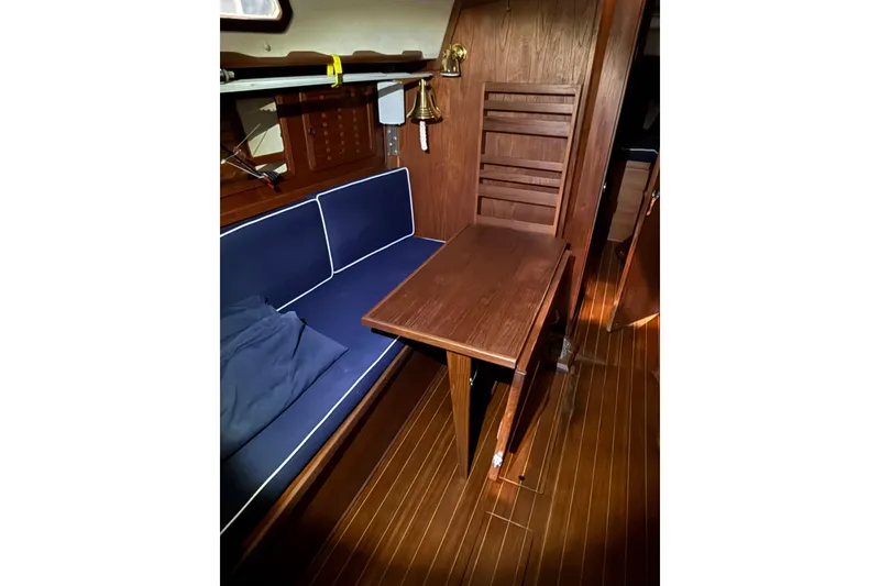Slide: The Image of 1986 Sabre 34 MK II yacht interior with wooden table and blue cushioned seating. - 40