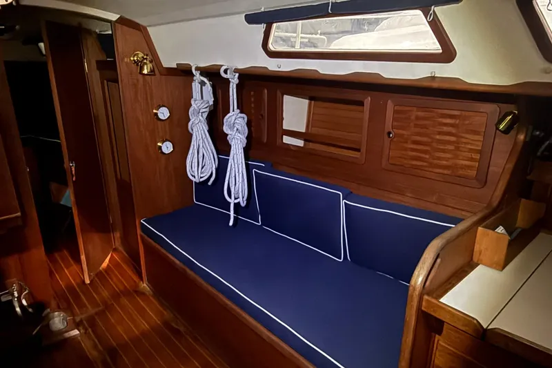 Slide: The Image of 1986 Sabre 34 MK II yacht interior with blue cushioned seating and wooden cabinetry. - 42