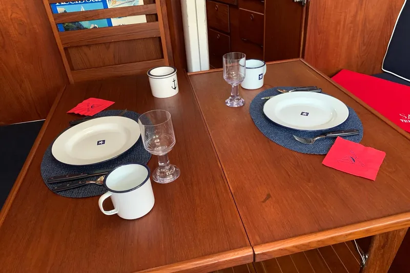 Slide: The Image of Dining setup inside 1986 Sabre 34 MK II yacht, featuring elegant tableware and nautical decor. - 44