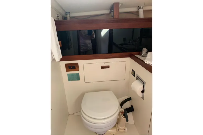 Slide: The Image of 1986 Sabre 34 MK II yacht bathroom with toilet and wooden accents. - 54