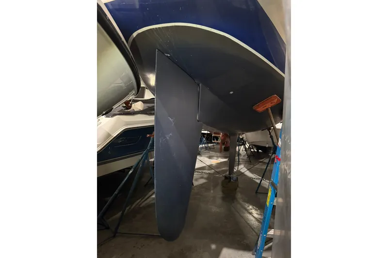 Slide: The Image of 1986 Sabre 34 MK II sailboat keel in storage, blue hull visible. - 61