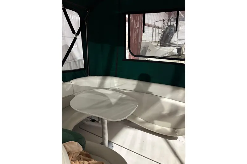 Slide: The Image of 2003 Four Winns 328 Vista boat interior with white seating and table. - 11