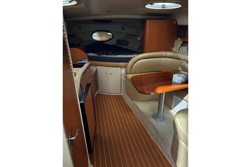 Slide: The Image of Interior of 2003 Four Winns 328 Vista boat with wood flooring and cozy seating area. - 16