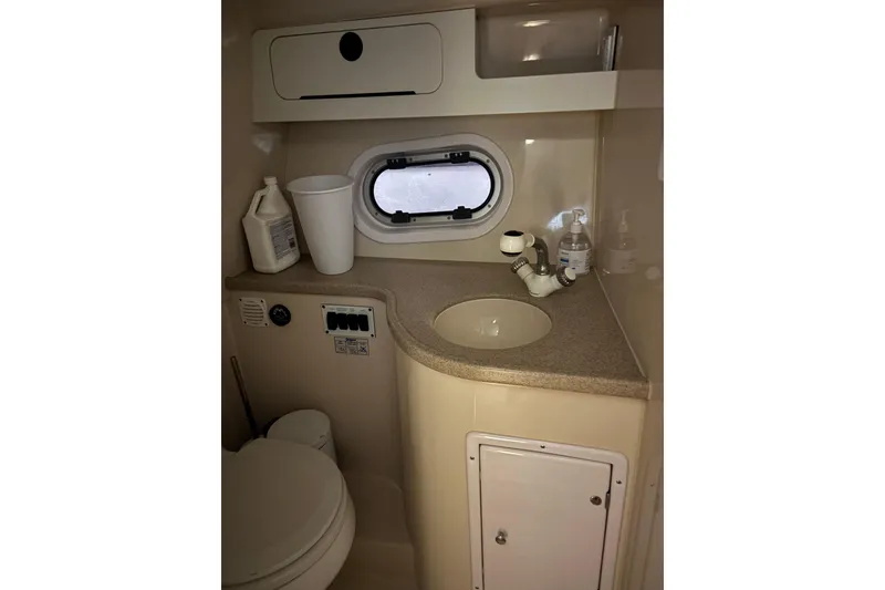 Slide: The Image of 2003 Four Winns 328 Vista boat bathroom with sink, toilet, and storage cabinet. - 19