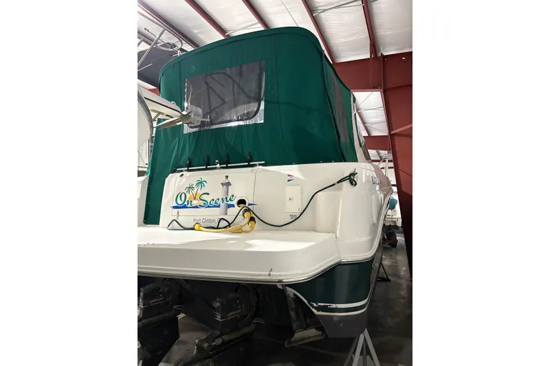Slide: The Image of 2003 Four Winns 328 Vista boat with green canopy in storage. - 2