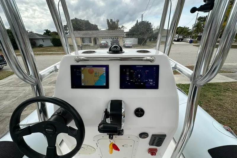 Slide: The Image of 2023 Ribcraft 5.85 boat dashboard with navigation screens and steering wheel. - 11