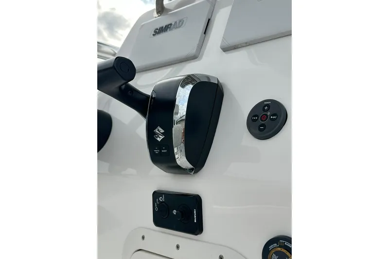 Slide: The Image of Control panel of 2023 Ribcraft 5.85 boat featuring Simrad electronics and Suzuki throttle. - 12