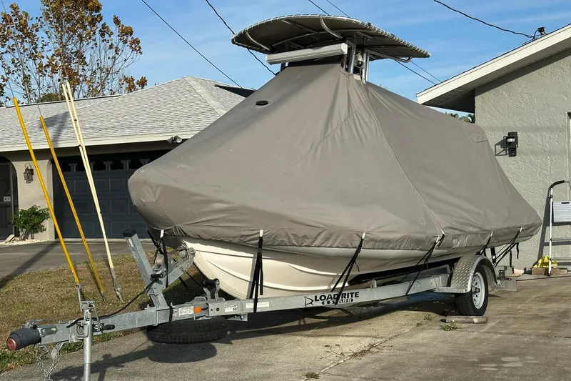 Slide: The Image of Covered 2023 Ribcraft 5.85 boat on trailer in driveway, ready for transport. - 19