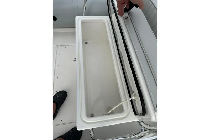 Slide: The Image of Open storage compartment on 2023 Ribcraft 5.85 boat deck. - 3