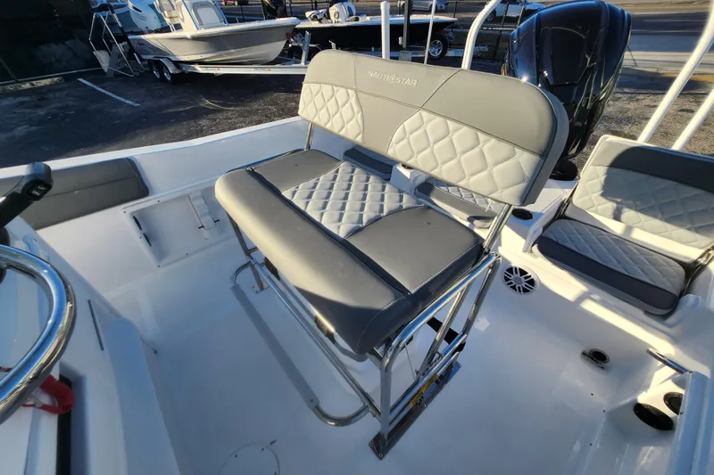 Slide: The Image of 2026 NauticStar 231 Hybrid boat interior with cushioned seating and steering wheel. - 4