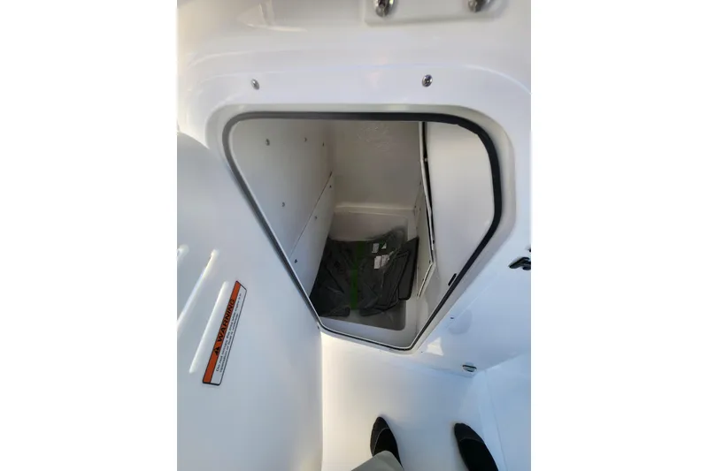 Slide: The Image of 2026 NauticStar 231 Hybrid storage compartment with open hatch, showcasing interior space. - 6