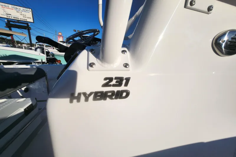 Slide: The Image of 2026 NauticStar 231 Hybrid boat detail with logo in sunlight. - 7
