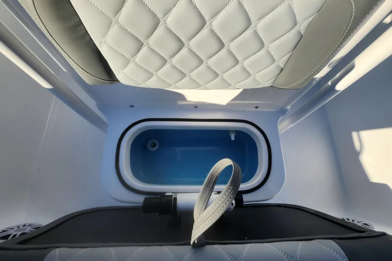Slide: The Image of 2026 NauticStar 231 Hybrid boat interior with cushioned seating and storage compartment. - 9