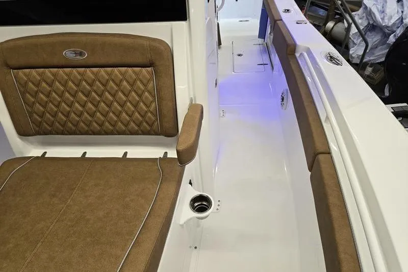 Slide: The Image of 2026 Sea Hunt Ultra 275 Coffin Box interior with brown cushioned seating and sleek design. - 11