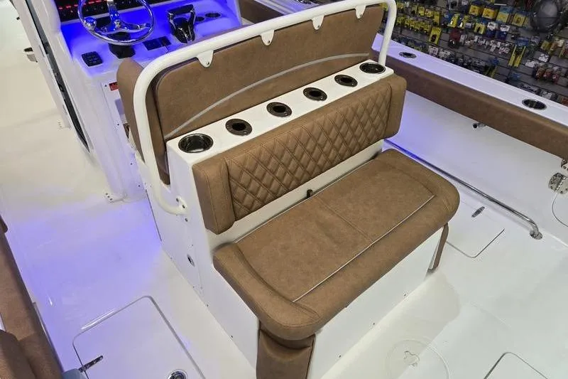 Slide: The Image of 2026 Sea Hunt Ultra 275 Coffin Box boat interior with brown seating and cup holders. - 17