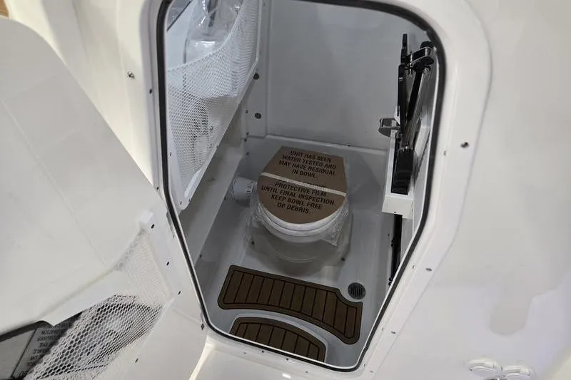Slide: The Image of 2026 Sea Hunt Ultra 275 Coffin Box boat interior with compact marine toilet. - 19
