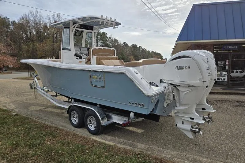 Slide: The Image of 2026 Sea Hunt Ultra 275 Coffin Box boat on trailer, dual Yamaha engines, parked outdoors. - 6
