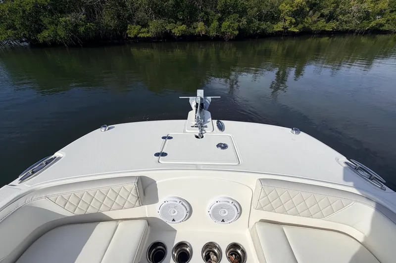 Slide: The Image of Bow view of 2026 World Cat 230 DC boat with seating and water backdrop. - 13