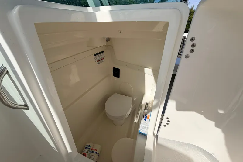 Slide: The Image of 2026 World Cat 230 DC boat interior with compact marine toilet. - 17