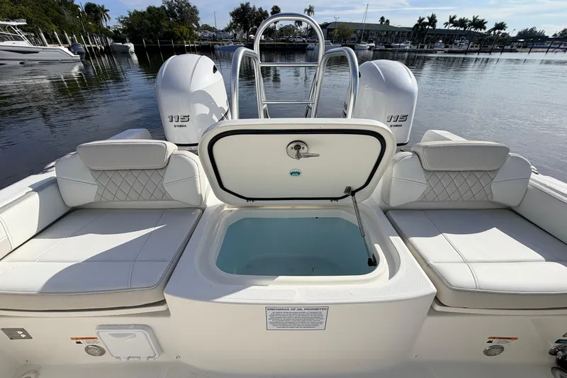 Slide: The Image of 2026 World Cat 230 DC boat with open storage compartment, dual Yamaha 115 engines, docked by water. - 20