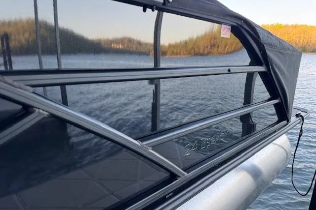 Slide: The Image of 2025 Bentley Pontoons Legacy 243 Swingback on serene lake with scenic backdrop. - 8