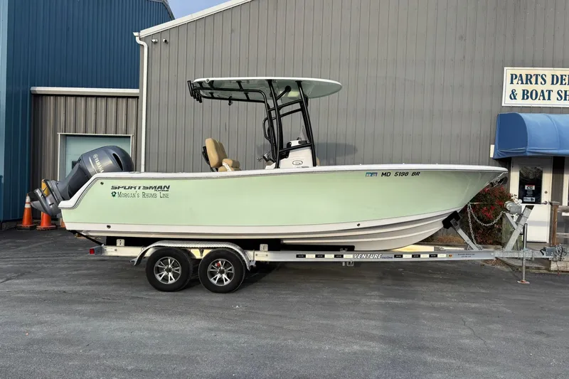 The Image of 2021 Sportsman Heritage 231 Center Console boat on trailer outside a parts and boat service shop. - 0