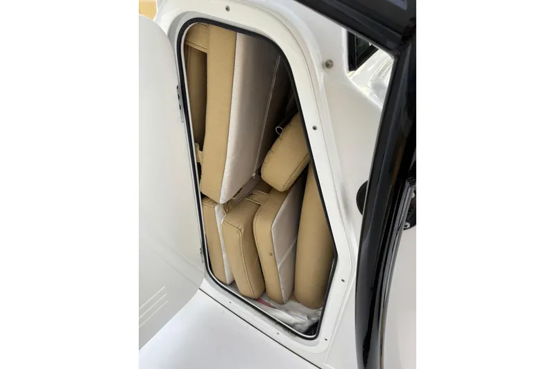 Slide: The Image of Storage compartment with beige cushions in 2021 Sportsman Heritage 231 Center Console boat. - 16