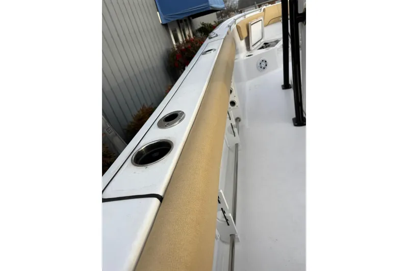 Slide: The Image of 2021 Sportsman Heritage 231 Center Console boat interior with rod holders and cushioned seating. - 17