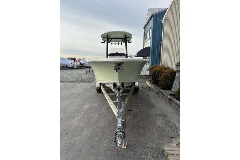 Slide: The Image of 2021 Sportsman Heritage 231 Center Console boat on trailer, parked near a building. - 2